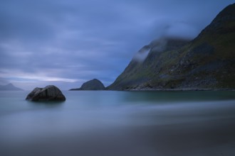 Landscape on the beach at Haukland. The mountains Veggen and Mannen on the right. The sky is cloudy