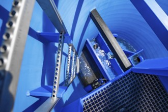 View into a blue tank with flowing water and several metal ladders, ENCW Netze Calw waterworks,