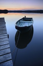 Quiet lake with jetty and rowing boat after sunset at dusk, Großer Lychensee, Lychen, Brandenburg,