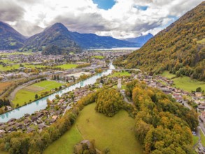 Sweeping views of a landscape with river and mountains under dramatic skies in an autumnal setting,