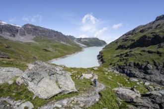 Mountaineer on hiking trail in front of Lac des Dix reservoir, Valais Alps, Valais, Switzerland,