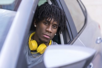 Close-up portrait of a serious african young man inside a car