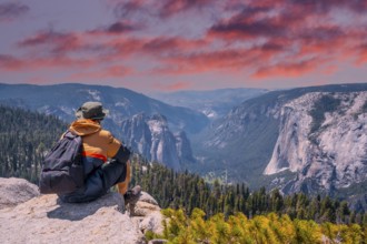A young winged seated Taft point looking at Yosemite National Park and El Capitan in sunset. United