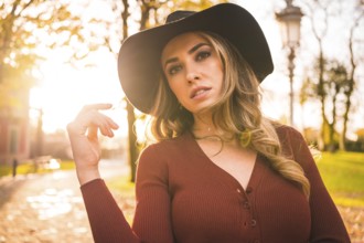 Lifestyle, portrait of a caucasian girl with a hat in a forest walking in autumn