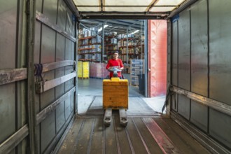 Views from inside the vehicle of a latin worker at a distribution warehouse loading boxes on a