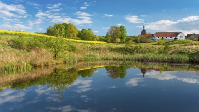 The small village of Teichwitz with half-timbered house, village church and blooming rape field