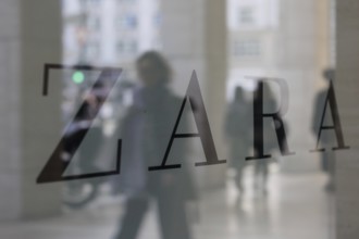 Company logo of the textile retail chain Zara, passers-by reflected in the shop window in Berlin,