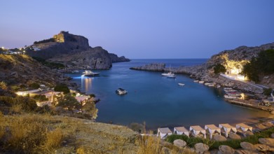 St Paul's Bay in the evening light, view of an illuminated bay with boats and calm water at dusk,