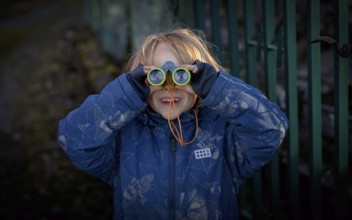 Little boy, 5 years, blond, looks through children's binoculars, toy, Stuttgart, Baden-Württemberg,