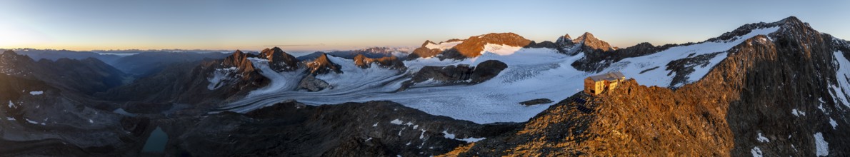PanoraAtmospheric sunrise in picturesque mountain landscape, alpenglow, aerial view, mountain hut