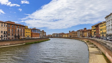 Rows of houses with pastel-coloured facades to the left and right of the River Arno, Pisa, Tuscany,