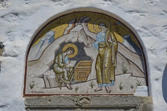 A mosaic wall painting on a church shows two holy figures in a religious scene, St John the