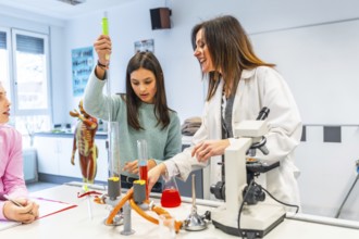 Female teacher assisting student using laboratory equipment during a chemistry experiment in a
