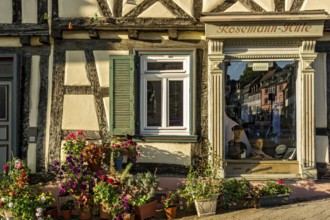 Idyllic old half-timbered house with floral decorations and shop window of milliner, milliner, hat