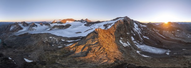 Atmospheric sunrise in a picturesque mountain landscape, alpenglow, aerial view, mountain hut
