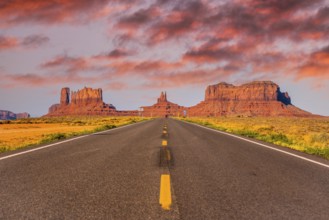 Sunset in the road with its yellow lines of Monument Valley, Utah