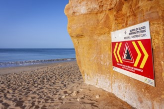 ROCKFALL UNSTABLE CLIFFS, KEEP A SAFE DISTANCE is written in English on a warning sign in Portugal