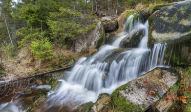Small waterfall at Kreuzbach, small mountain stream flows over stones covered with moss, Bavarian