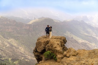 Couple enjoying breathtaking view of volcanic mountains and valleys in gran canaria, spain