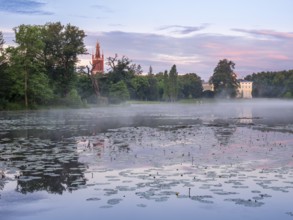 View over Lake Wörlitz to Wörlitz Castle and the Bible Tower of St Peter's Church in Wörlitz Park