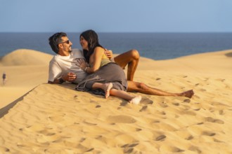 Tourists enjoying summer holidays lying on the sand in the maspalomas dunes, gran canaria, canary