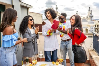 Multi-ethnic friends celebrating a rooftop birthday party together