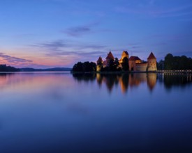 Evening view of Trakai Island Castle in lake Galve illuminated in the night, Lithuania, Europe