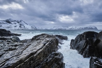 Waves of Norwegian sea crushing at rocky coast in fjord. Vikten, Lofoten islands, Norway, Europe