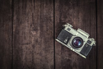 Photography concept background, old retro vintage camera on grunge wooden texture