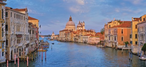 Panorama of Venice Grand Canal with boats and Santa Maria della Salute church on sunset from Ponte
