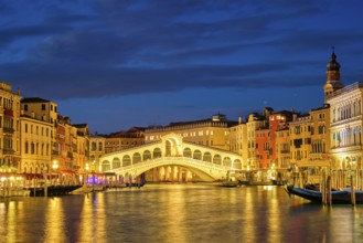 Famous Venetian tourist landmark Rialto bridge (Ponte di Rialto) over Grand Canal illuminated at