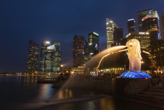 SINGAPORE, JANUARY 1, 2014: Night view of Singapore Merlion at Marina Bay against Singapore skyline