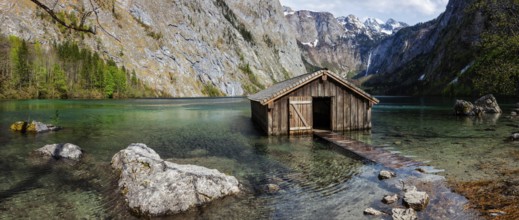 Panorama of Obersee mountain lake with boat dock hangar in Alps. Bavaria, Germany, Europe