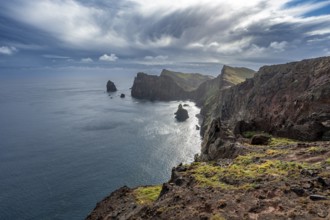 Red cliffs and rocks in the sea, coastal landscape with dramatic sky, Ponta de São Lourenço,