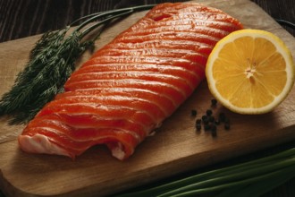 Fresh salmon piece on wooden cooking board with vegetables