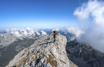 Mountaineer on a rocky narrow mountain path with mountain panorama, mountain tour to the summit of