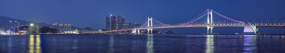 Panorama of Gwangan Bridge and skyscrapers illuminated in the night. Busan, South Korea, Asia