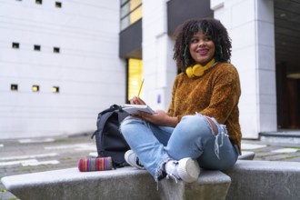 Portrait of black ethnic girl sitting in college doing classwork or studying for an exam