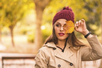 Outdoor atmospheric lifestyle portrait of a beautiful young woman in a forest in autumn at sunset