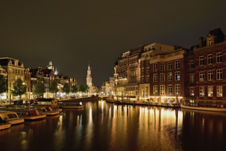 Historic buildings and mint tower illuminated at night, Singelgracht, Amsterdam, North Holland,