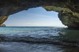 Breathtaking turquoise waves lapping the shore from inside a cave in cala domingos, mallorca,