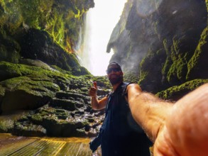 A tourist inside the Iris grotto at the Cola de Caballo Waterfall in the Monasterio de Piedra