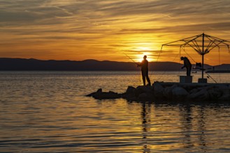 Anglers at sunset in Podgora, Croatia, Europe