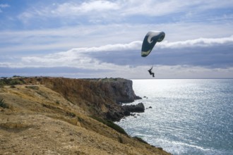 Sagres, Algarve, Portugal - Paraglider flying on the town beach Praia da Mareta, at the back left