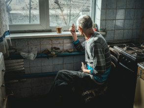 A man looks out of his kitchen window at the site of the Hroza massacre. 59 people were killed in a