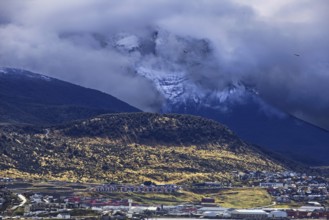Ushuaia against a magnificent mountain backdrop under a cloudy, mysterious sky, Ushuaia, Argentina,