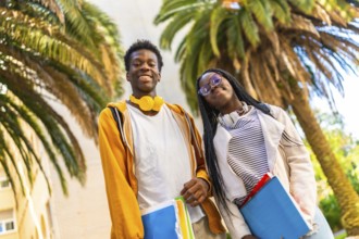 Low angle view portrait of two african american students smiling proud in the campus