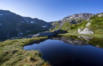 Mountains reflected in a lake, hike to the summit of Rundfjellet, Svolvaer, Nordland, Norway,