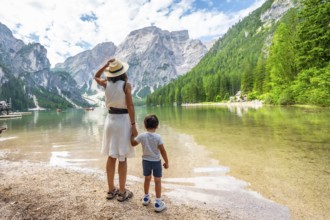 Mother and son enjoying summer vacation at lake braies, surrounded by stunning mountain scenery in