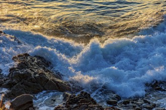 Waves foam over rocks during sunset in Salvador, Bahia, Salvador, Bahia, Brazil, South America